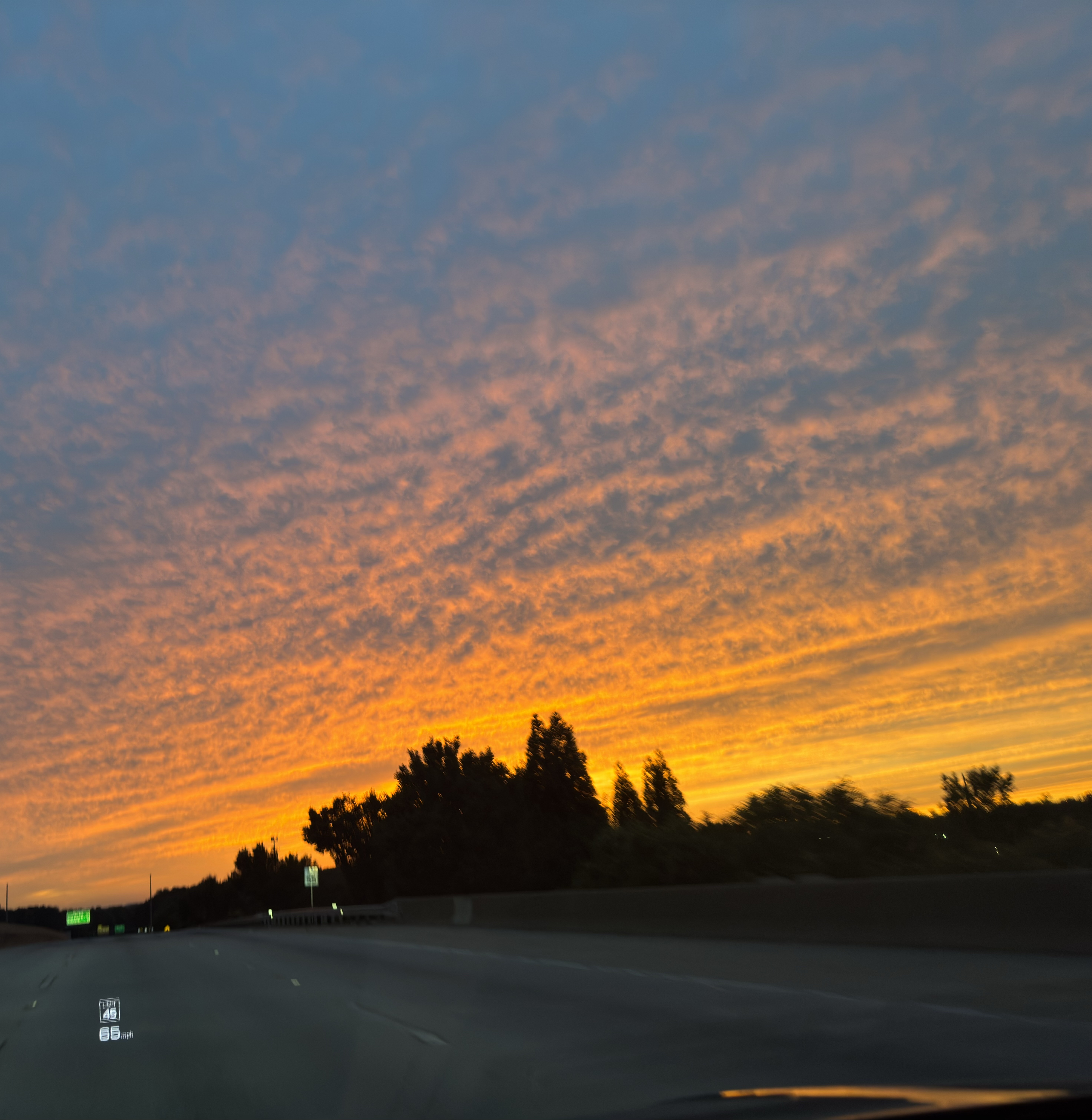Sunset over highway from car windshield